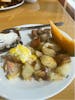 Salmon Benedict, potatoes & onions, breakfast bread, sausage, and cantaloupe. 