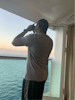 My hubby on our balcony embarkation day with the comp binoculars  