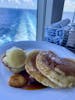 Eggs benedict and pancakes with banana compote